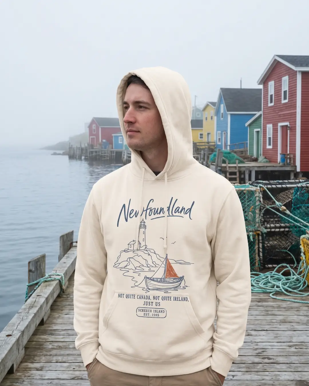 Man wearing Newfoundland vintage hoodie on a wharf with colourful row houses behind